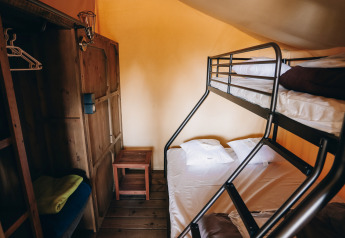 Interieur van een safari tent Slow Lodge met stapelbedden en houten kast op Camping Seasonova Ile de Ré, Frankrijk.