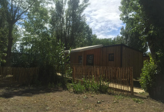 Casa móvil adaptada para discapacitados en Camping Seasonova Ile de Ré, Francia, entre árboles y valla.