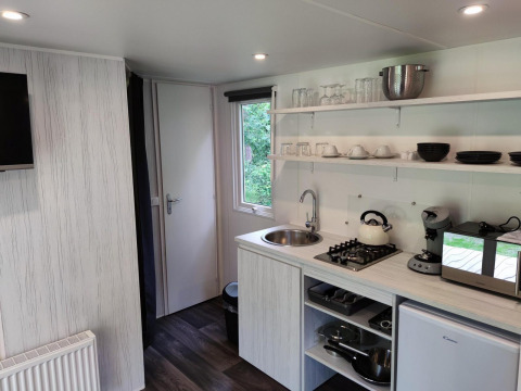 Moderne tekøkken i Glamping Coco Sweet-lodgen på Bospark De Brenkberg, Nederlandene, med køkkenudstyr.