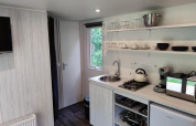 Moderne tekøkken i Glamping Coco Sweet-lodgen på Bospark De Brenkberg, Nederlandene, med køkkenudstyr.