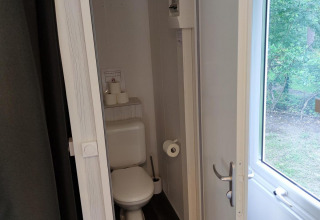 Baño pequeño con inodoro y ventana en Glamping Coco Sweet, Bospark De Brenkberg, Países Bajos.