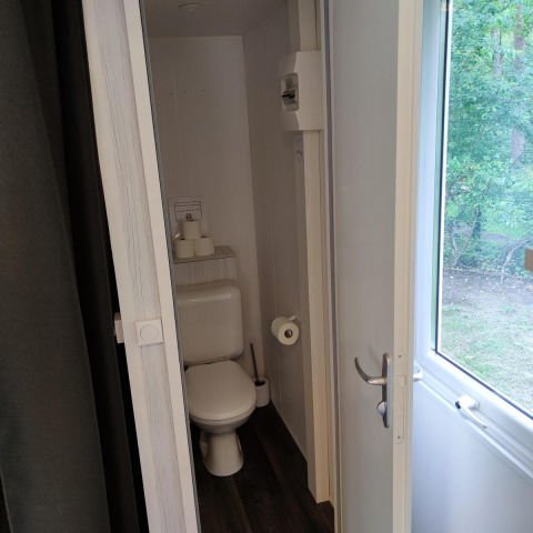 Baño pequeño con inodoro y ventana en Glamping Coco Sweet, Bospark De Brenkberg, Países Bajos.