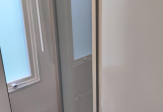 Interior de la cabaña Glamping Coco Sweet en Bospark De Brenkberg, Países Bajos, con ventanas visibles.