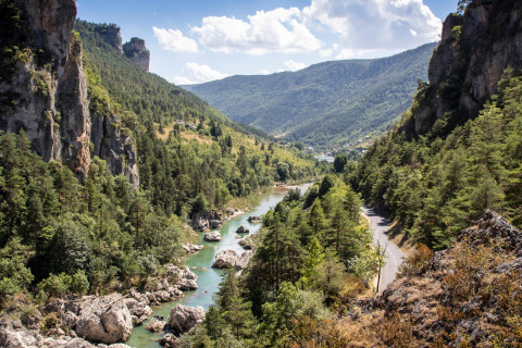 Naturskønt udsigt over flod og klipper ved Huttopia Gorges du Tarn i Occitanie, Frankrig, omgivet af bakker.