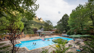 Piscina al aire libre en Huttopia Gorges du Tarn, parque vacacional en Occitanie, Francia, rodeada de naturaleza.