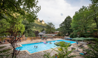 Piscina al aire libre en Huttopia Gorges du Tarn, parque vacacional en Occitanie, Francia, rodeada de naturaleza.