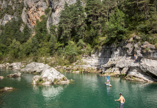 Peddelsurfers genieten van het water tussen rotsen en bossen bij Massegros-Causses-Gorges, Frankrijk.