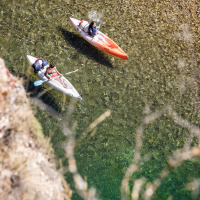 Dos personas navegan en kayak sobre aguas claras cerca de Massegros-Causses-Gorges, Occitania, Francia.