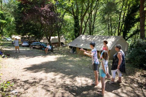 Familia divirtiéndose en campamento con tiendas en Huttopia Gorges du Tarn, Occitania, Francia.