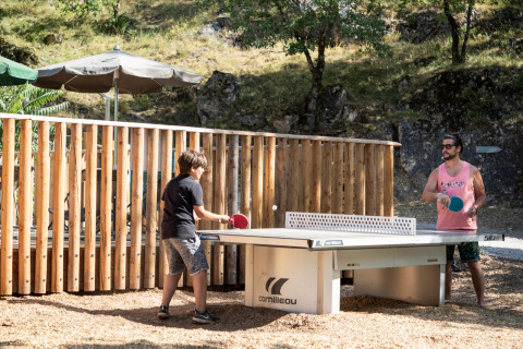 Zwei Personen spielen Tischtennis im Freien im Ferienpark Huttopia Gorges du Tarn in Okzitanien, Frankreich.