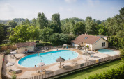 Piscine extérieure avec transats et parasols au Huttopia La Plage Blanche en Bourgogne-Franche-Comté.