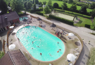 Luchtbeeld van zwembad en ontspanningsruimte met bezoekers in Huttopia La Plage Blanche, Bourgogne-Franche-Comté, Frankrijk.