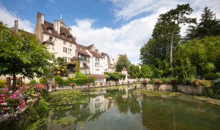 Encantador paisaje cerca de Ounans, Bourgogne-Franche-Comté, Francia, con casas antiguas, estanque y vegetación.