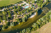 Luftfoto af Huttopia La Plage Blanche feriepark med swimmingpool, grønne områder og flod i Bourgogne-Franche-Comté.