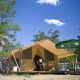 Safari telt Bungalow Tent Classic med cykler, paraply og campingmøbler under en blå himmel med skyer.