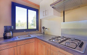 Cucina della Mobile home Vancouver a Huttopia Wattwiller, Francia, con fornello a gas, lavello e macchina da caffè.