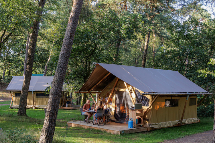 Tienda safari Canadienne Tent II en Huttopia Lac de Serre Ponçon, Francia, familias disfrutan el exterior.