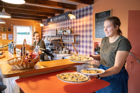 Dos empleadas sirven comida a los huéspedes en el restaurante de Huttopia Wattwiller, Grand Est, Francia.