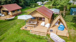Vista aerea della tenda safari Cozy Lodge con veranda, area salotto, amaca e bagno privato in campeggio.