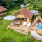 Luchtfoto van Cozy Lodge safaritent met veranda, zithoek, hangmat en privé sanitair op een camping.