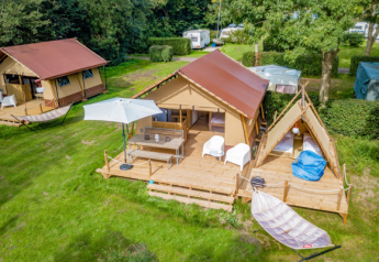 Vista aérea de una tienda safari Cozy Lodge con terraza, zona de estar, hamaca y baño privado en camping.