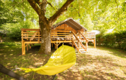Safari Lodge + Teeny Lodge safari tent at Camping Les Tailladis, France, with wooden deck and yellow hammock shade.