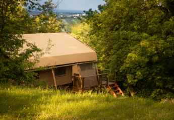 Safari-tent Desert Lodge verscholen tussen bomen bij Camping Centro Vacanze San Marino in Italië.