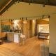 Indvendig udsigt til et safari-telt kaldet Wood Lodge med trægulve, køkken og dobbeltseng.