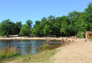 Strand og sø med folk, der bader og soler sig ved Camping Seasonova L'Etang des Bois i Centre-Val de Loire.