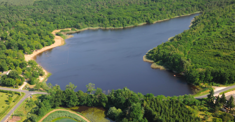 Vue aérienne d’un lac entouré de forêts près de Vieilles-Maisons-sur-Joudry, en Centre-Val de Loire, France.