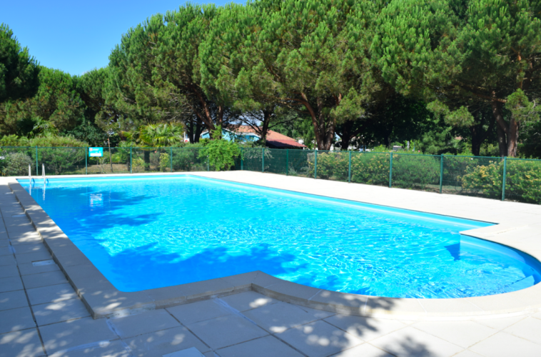 Außenpool im Feriendorf Village Seasonova Bassin d'Arcachon, umgeben von Bäumen in Nouvelle-Aquitaine, Frankreich.