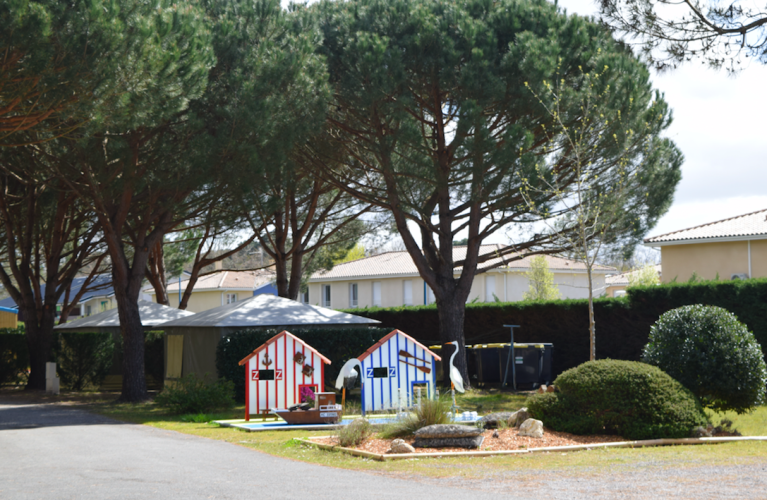 Foto vom Ferienpark Village Seasonova Bassin d'Arcachon mit Bäumen, Spielhäuschen und Häusern in Nouvelle-Aquitaine, Frankreich.