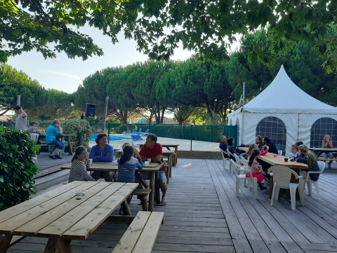 Area pranzo all'aperto con tavoli in legno e famiglie al Village Seasonova Bassin d'Arcachon, Francia.