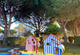 Kleurrijke miniatuurhuisjes onder dennen in Village Seasonova Bassin d'Arcachon, Nouvelle-Aquitaine, Frankrijk.