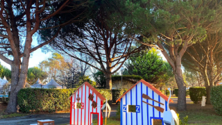 Colorida villa en miniatura bajo pinos en Village Seasonova Bassin d'Arcachon, Nouvelle-Aquitania, Francia.