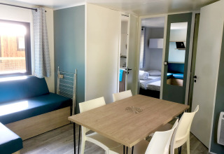 Dining and living area inside the Prestique cabin at Camping Seasonova L'Etang des Bois in France.