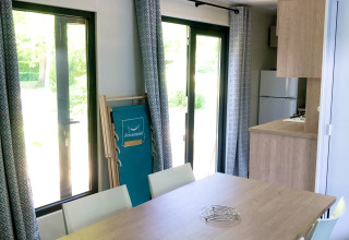 Luminoso comedor de la cabaña Prestique en Camping Seasonova L'Etang des Bois en Francia, con decoración moderna.