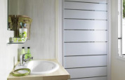 Modernes Badezimmer in einer Glamping-Unterkunft mit Dusche, Waschbecken, Spiegel und Fenster.