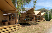 Fila de tiendas safari Wood Lodge con porche en Village Seasonova Bassin d'Arcachon, camping en Francia.