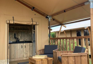 Terraza de madera con asientos frente a una tienda safari Wood Lodge con baño en Village Seasonova Bassin d'Arcachon.