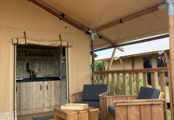 Terraza de madera con asientos frente a una tienda safari Wood Lodge con baño en Village Seasonova Bassin d'Arcachon.