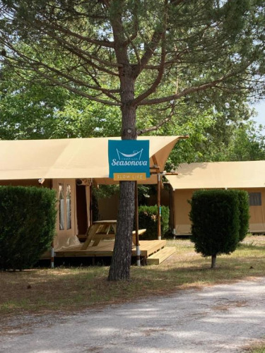 Safari-Zelt Slow Lodge + Bad im Village Seasonova Bassin d'Arcachon, Frankreich, mit Schild an einem Baum.