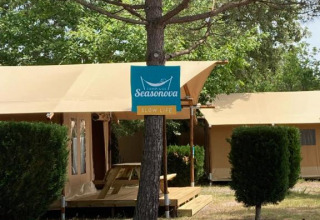 Tienda safari Slow Lodge + baño en Village Seasonova Bassin d'Arcachon, Francia, con árbol y cartel visible.