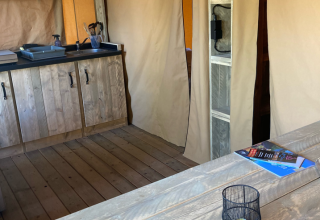 Interior de una tienda safari en Slow Lodge con muebles de madera y cocina, en Village Seasonova Bassin d’Arcachon, Francia.