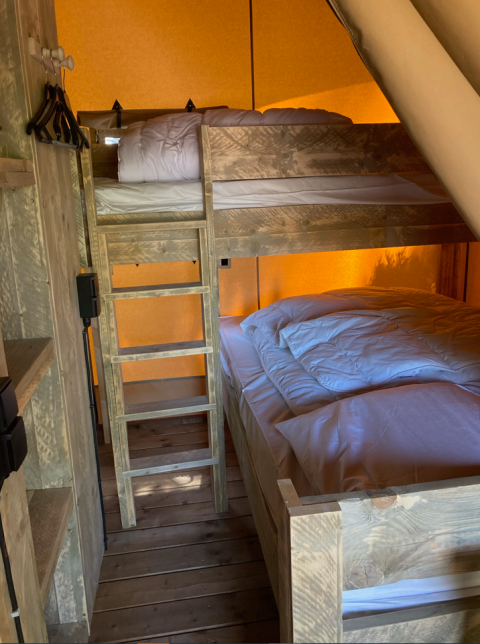 Literas de madera y cama doble con sábanas blancas en una tienda safari de Slow Lodge en Village Seasonova Bassin d'Arcachon.
