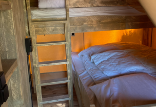 Wooden bunk bed and double bed with white bedding inside a safari tent at Slow Lodge, Village Seasonova Bassin d'Arcachon.