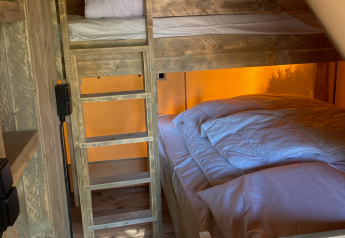 Literas de madera y cama doble con sábanas blancas en una tienda safari de Slow Lodge en Village Seasonova Bassin d'Arcachon.
