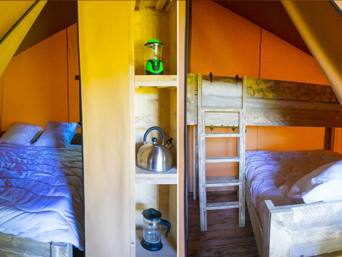 Interno di una tenda safari con letto matrimoniale, letto a castello e mensole con lanterna, bollitore e caffettiera.