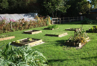 Erhöhte Gartenbeete auf einer grünen Wiese im Camping Seasonova Haliotis, Ferienpark in der Normandie, Frankreich.