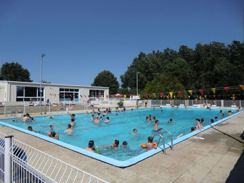Piscina al aire libre con muchas personas disfrutando del sol en Camping Seasonova Les Plages de Loire, Francia.